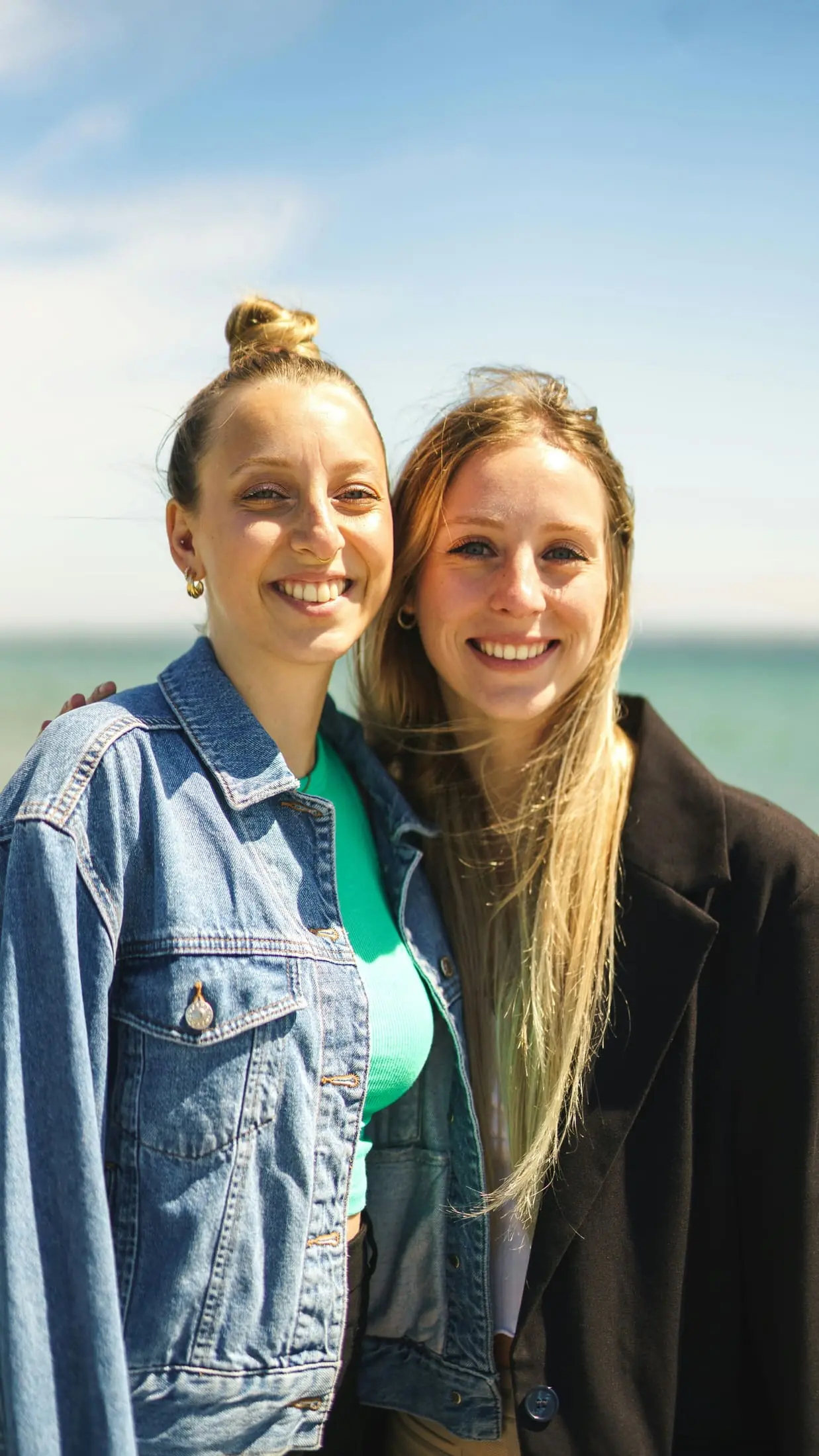 Two friends smiling by the water