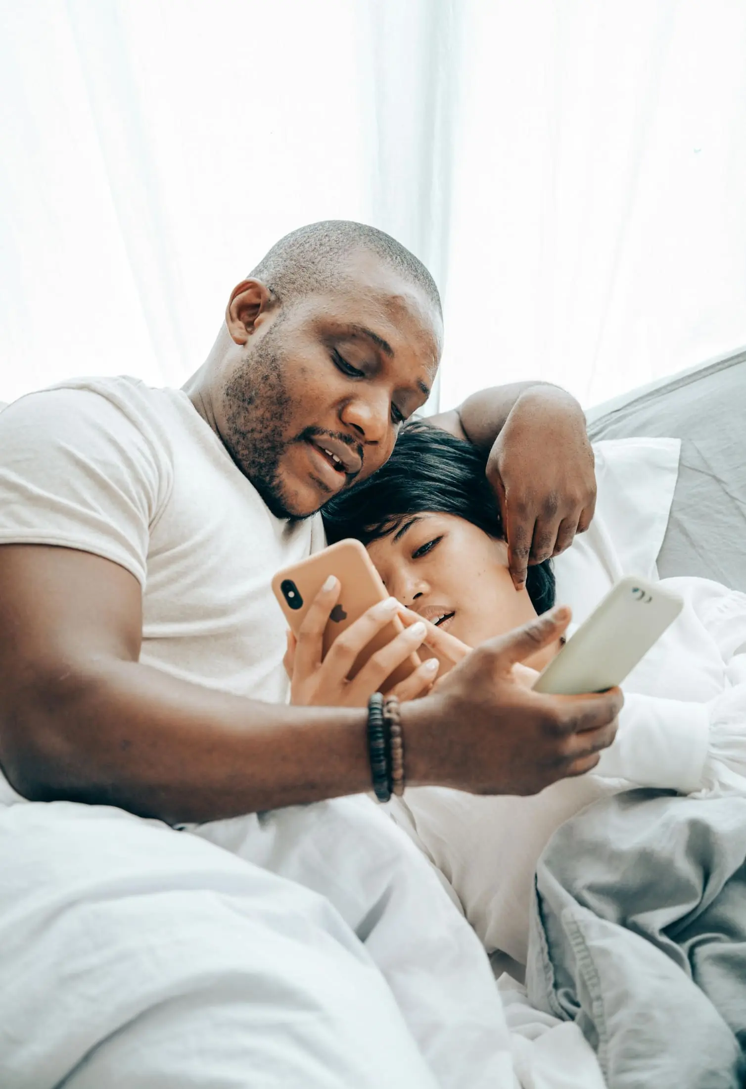 Two people looking at phones together at home