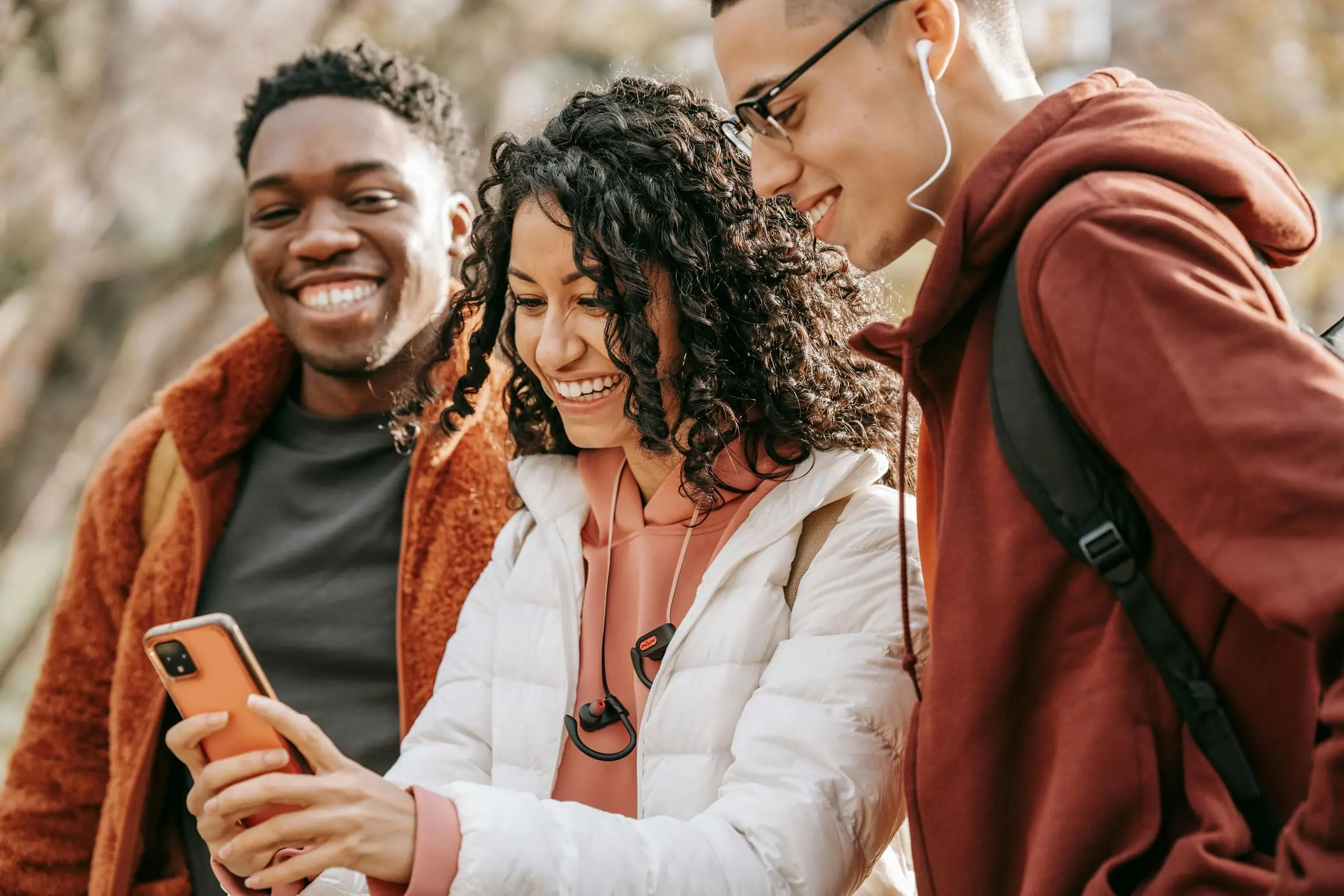 Friends laughing together while looking at a phone